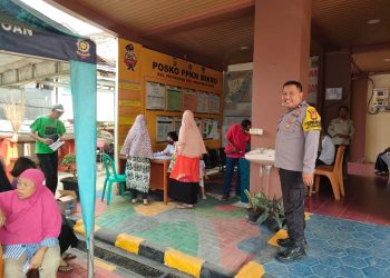 Bhabinkamtibmas Kelurahan Petogogan Monitor Pembagian Bantuan Beras di Kantor Kelurahan Petogogan