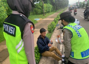 Polwan Polres Metro Bekasi Sigap Menolong Pengendara Motor yang Tergelincir Saat Gatur Lalin