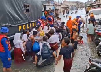 Ditpolairud Polda Metro Jaya Bantu Anak Sekolah di Tengah Banjir Rob Muara Angke
