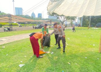 Polres Metro Jakarta Pusat Turun Tangan Bersihkan Sampah Usai May Day di Monas