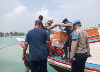 Polisi Baik Polsek Kepulauan Seribu Utara Bantu Penumpang Turun dari Kapal, Tegaskan Pengawasan Ketat Barang Bawaan