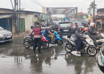 Polsek Babelan Kendalikan Arus Lalu Lintas Pagi di Pertigaan Jembatan Besi
