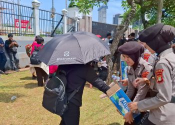 Polwan Polda Metro Bagikan Air Mineral ke Massa Aksi di Depan DPR/MPR