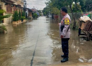 Antisipasi Dampak Cuaca Ekstrem, Bhabinkamtibmas Polsek Medan Satria Pantau Titik Genangan di Perumahan Harapan Indah