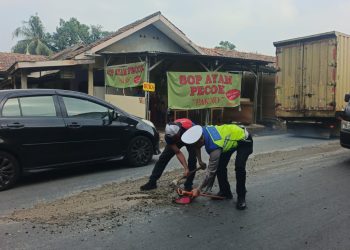 Kanit Lantas Polsek Serang Baru Bersihkan Ceceran Semen di Jalan, Cegah Kemacetan dan Kecelakaan