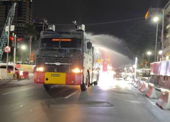 Brimob Polda Metro Jaya Semprot Jalan dan Bagikan Masker Antisipasi Abu Vulkanik Anak Krakatau